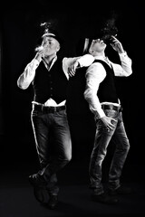 two twin brothers in gangster style posing. hats, vests, white shirts. white and black.