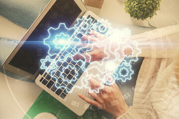 Double exposure of woman hands working on computer and financial theme hologram drawing. Top View. Business concept.