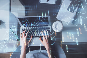 Double exposure of woman hands working on computer and forex chart hologram drawing. Top View. Financial analysis concept.