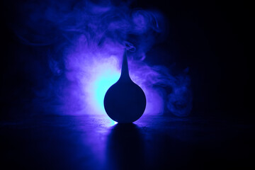 Blue enema on dark background with backlight. Creative artwork decorated with light.
