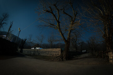 Full moon over quiet village at night. Beautiful night landscape of old town street with lights