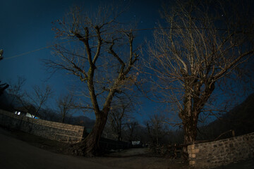Full moon over quiet village at night. Beautiful night landscape of old town street with lights