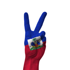 Hand making victory sign, haiti painted with flag as symbol of victory, win, success - isolated on white background