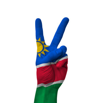 Hand making victory sign, namibia painted with flag as symbol of victory, win, success - isolated on white background