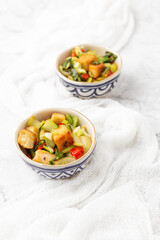 Tofu and Vegetables Stir Fry in Blue and White Bowls on White Background