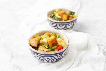 Tofu and Vegetables Stir Fry in Blue and White Bowls on White Background