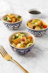 Tofu and Vegetables Stir Fry in Blue and White Bowls on White Background