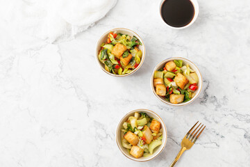 Tofu and Vegetables Stir Fry in Blue and White Bowls on White Background