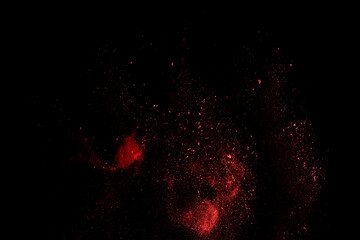 Red powder explosion on black background. Paint Holi.