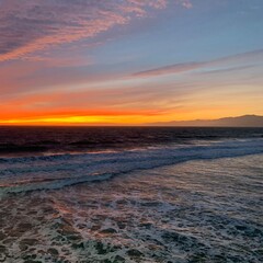 Fototapeta na wymiar Vibrant tricolor sunset over coastal island seascape