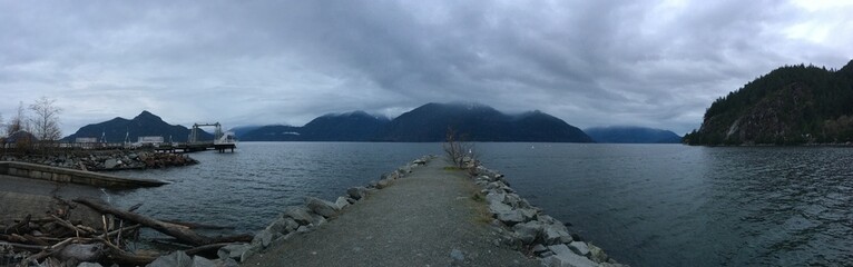 Panoramic view of mountainside lake from rocky pier