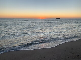 Vibrant sunset over calm sandy beach shoreline