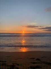 Fototapeta premium Seascape view of vibrant sunset over calm beach waters