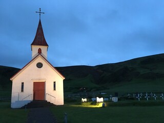 Simple church and cemetery in grassy mountain valley