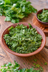 Bowl with dry parsley on table