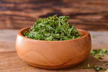 Bowl with dry parsley on table