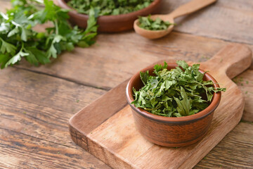 Bowl with dry parsley on table