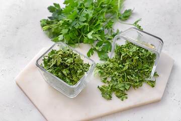 Bowls with dry and fresh parsley on white background