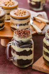 Delicious cupcakes in jars on color background
