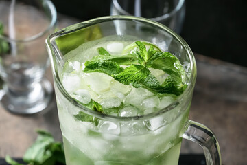 Jug of fresh mojito on table, closeup