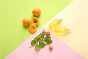 Bottles of apricot essential oil on color background