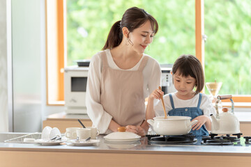 台所で料理を作るお母さんと女の子