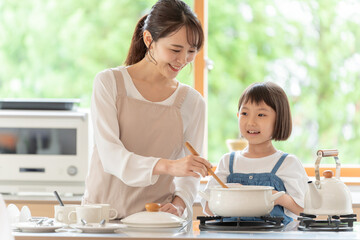 台所で料理を作るお母さんと女の子