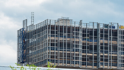 Building under construction, scaffolding and other construction elements.