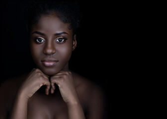 close up of beautiful young black woman with beautiful skin and makeup looking at camera