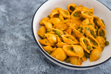 plant-based food, vegan shells pasta with pumpkin sauce and peas