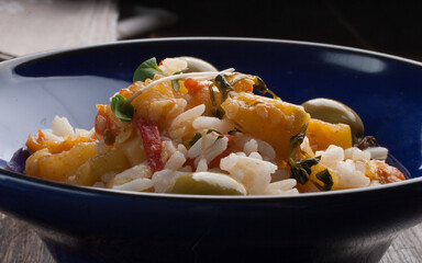 Risotto in blue plate on the wooden table