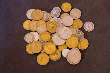 lot of old coins on a black towel.