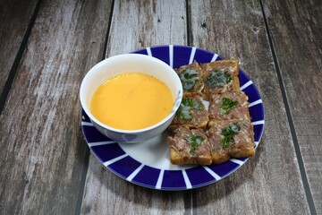 Traditional ingredient set of pork bun or minced pork toast on the plate. Famous party snack menu in Asia festival or ceremony. Bread topping with marinated pork and coriander ready to be fried. 