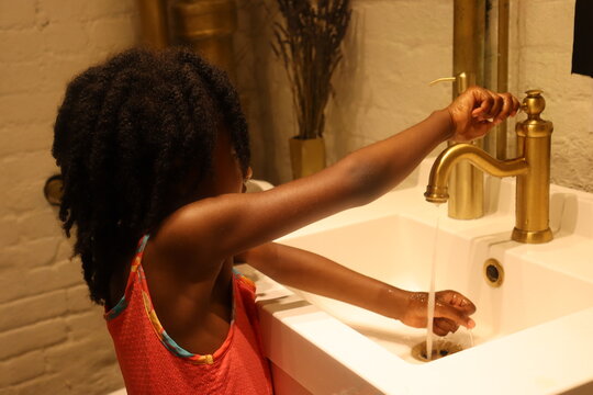 Young Black Child Washing Hands In Upscale Sink Indoors