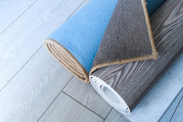 Carpet and linoleum are rolled up and lie on the laminate floor