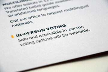 Closeup paper with 'In-Person Voting' info