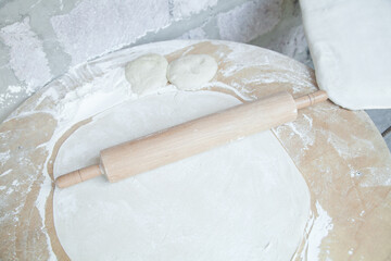 Dough with rolling pin on table.