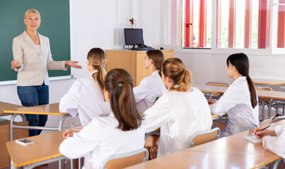 Female professor giving lesson for medical students in lecture hall