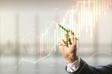 Man hand with pen working with abstract virtual financial graph on blurred office background, financial and trading concept. Multiexposure