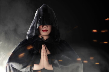 Asian witch woman with black cloak doing mystical ritual