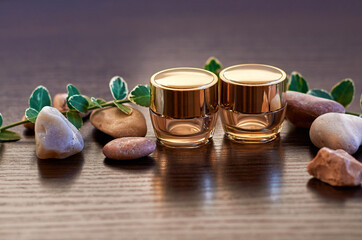 Cosmetic mock up bottles. Branding products, beauty background. Natural skincare beauty product concept on a dark background. pebbles and green leaves