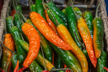 Basket with red and green chilli pepper in the shop .