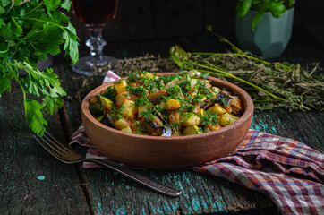 Vegetable roast eggplant and potatoes in a clay plate (ketsa). Homemade healthy food in a rustic style.