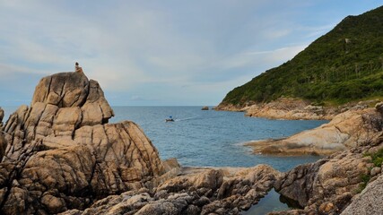 Fototapeta na wymiar Woman spend time at rocky coastline by the sea view, koh Phangan island, Thailand