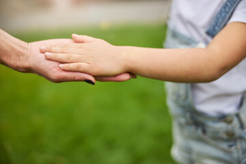 Parent holding the hand of a little child