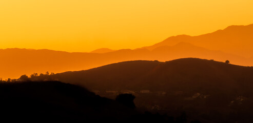 Orange Sky and Haze with Layered Mountains in the Background