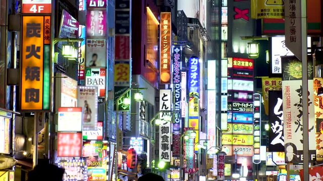 SHINJUKU, TOKYO, JAPAN : View of street and sign (billboard and neon) at Kabukicho downtown area at night. All the logo are blurred or overwritten for this video. Japanese nightlife concept shot.