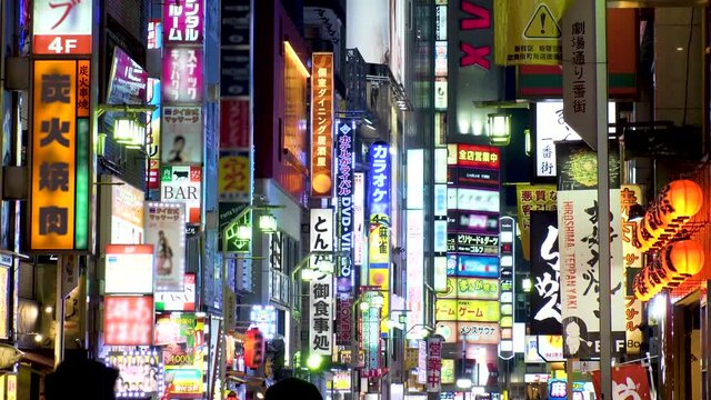 SHINJUKU, TOKYO, JAPAN : View of street and sign (billboard and neon) at Kabukicho downtown area at night. All the logo are blurred or overwritten for this video. Japanese nightlife concept shot.