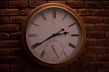 Round wall mounted clock with roman numerals.