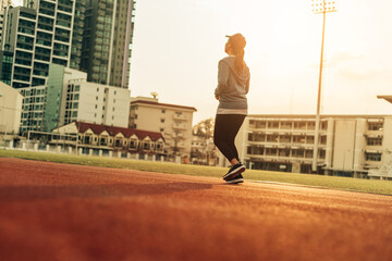 Runner jogging in sun light. Female fitness model training in the city. Healthy and lifestyle concept